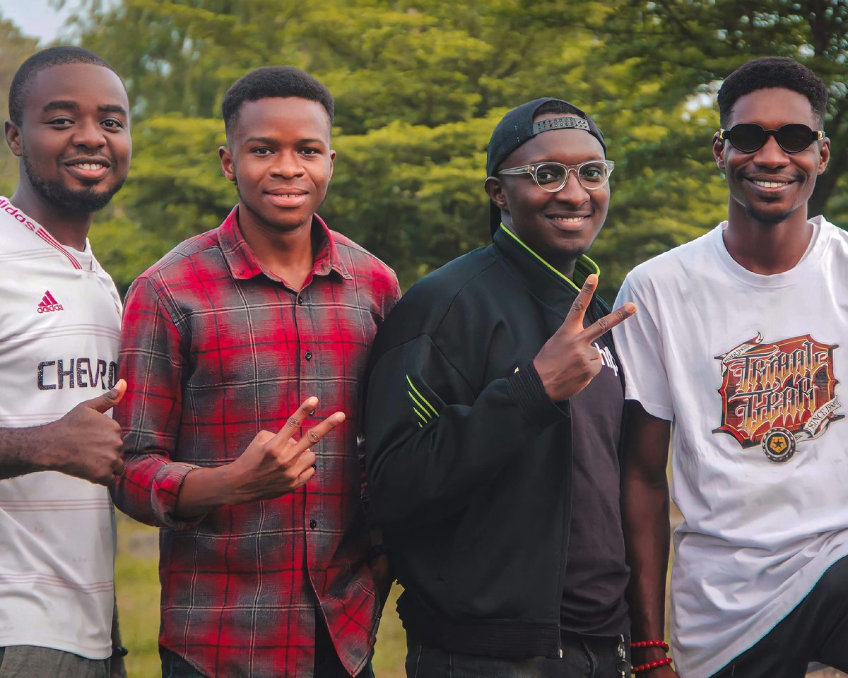 Four young men smiling together outdoors
